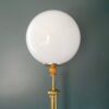 A vintage brass floor lamp with a large glass dome by Fiona Bradshaw Designs
