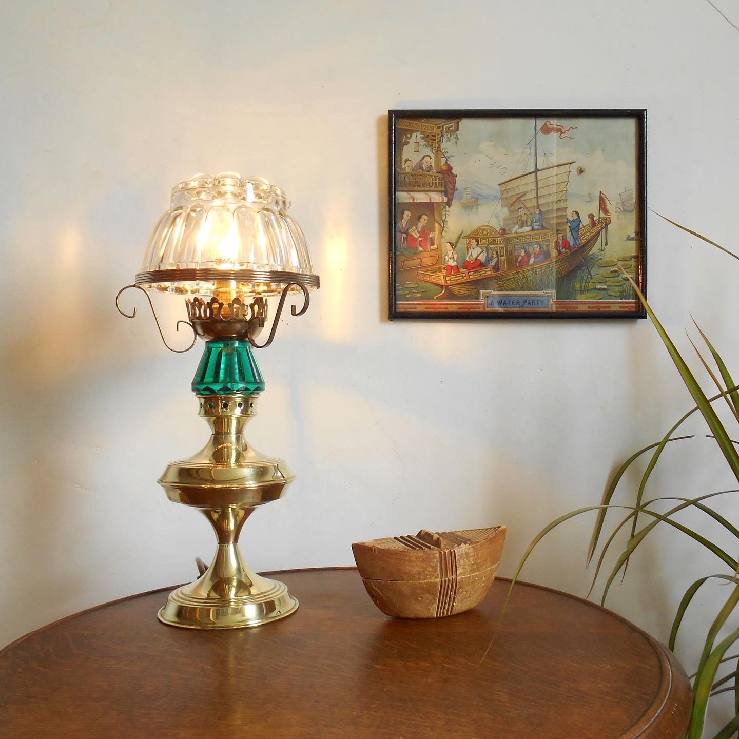 A vintage brass table lamp with a glass jelly mould shade