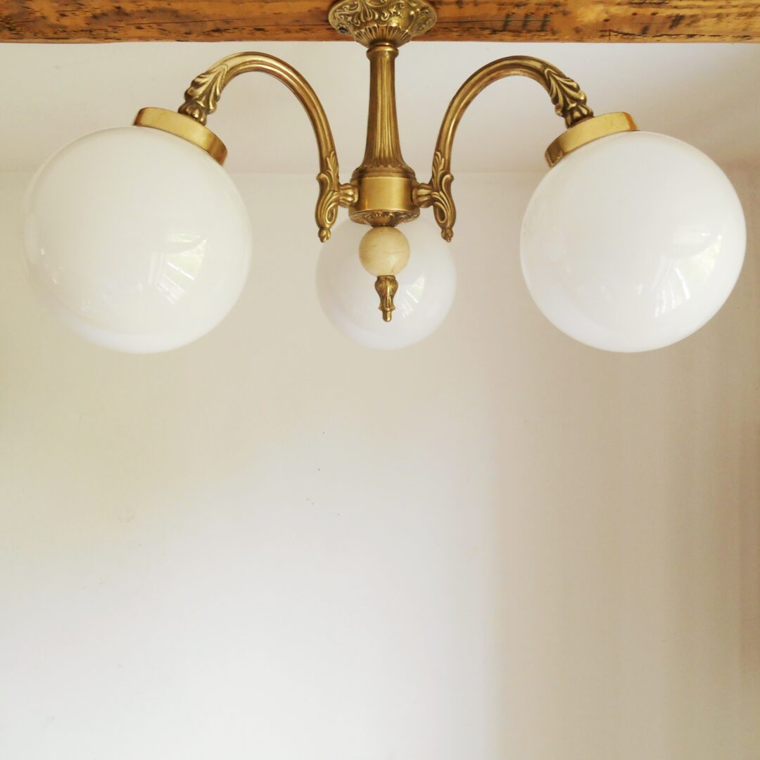 A solid brass Art Deco chandelier with three glass globe shades by Fiona Bradshaw Designs