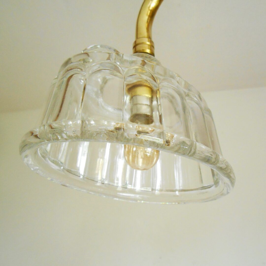 A solid brass chandelier with three glass jelly mould shades by Fiona Bradshaw Designs