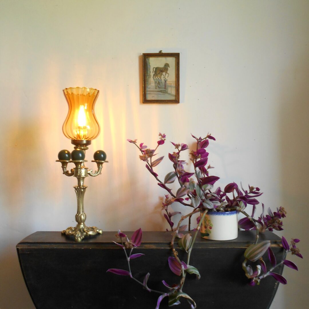 A bespoke brass table lamp with an amber glass shade by Fiona Bradshaw Designs.