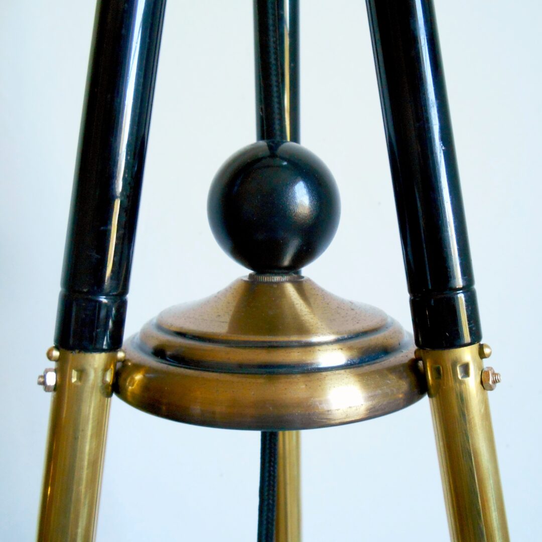 A brass tripod floor lamp with a retro glass shade by Fiona Bradshaw Designs