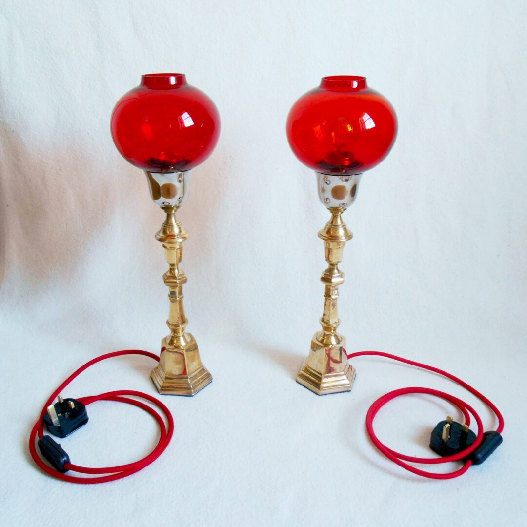 A pair of vintage brass table lamps with striking red glass shades by Fiona Bradshaw Designs