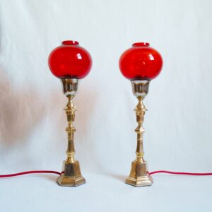 A pair of vintage brass table lamps with striking red glass shades by Fiona Bradshaw Designs
