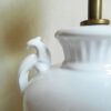 A ceramic white table lamp with a green glass shade by Fiona Bradshaw Designs