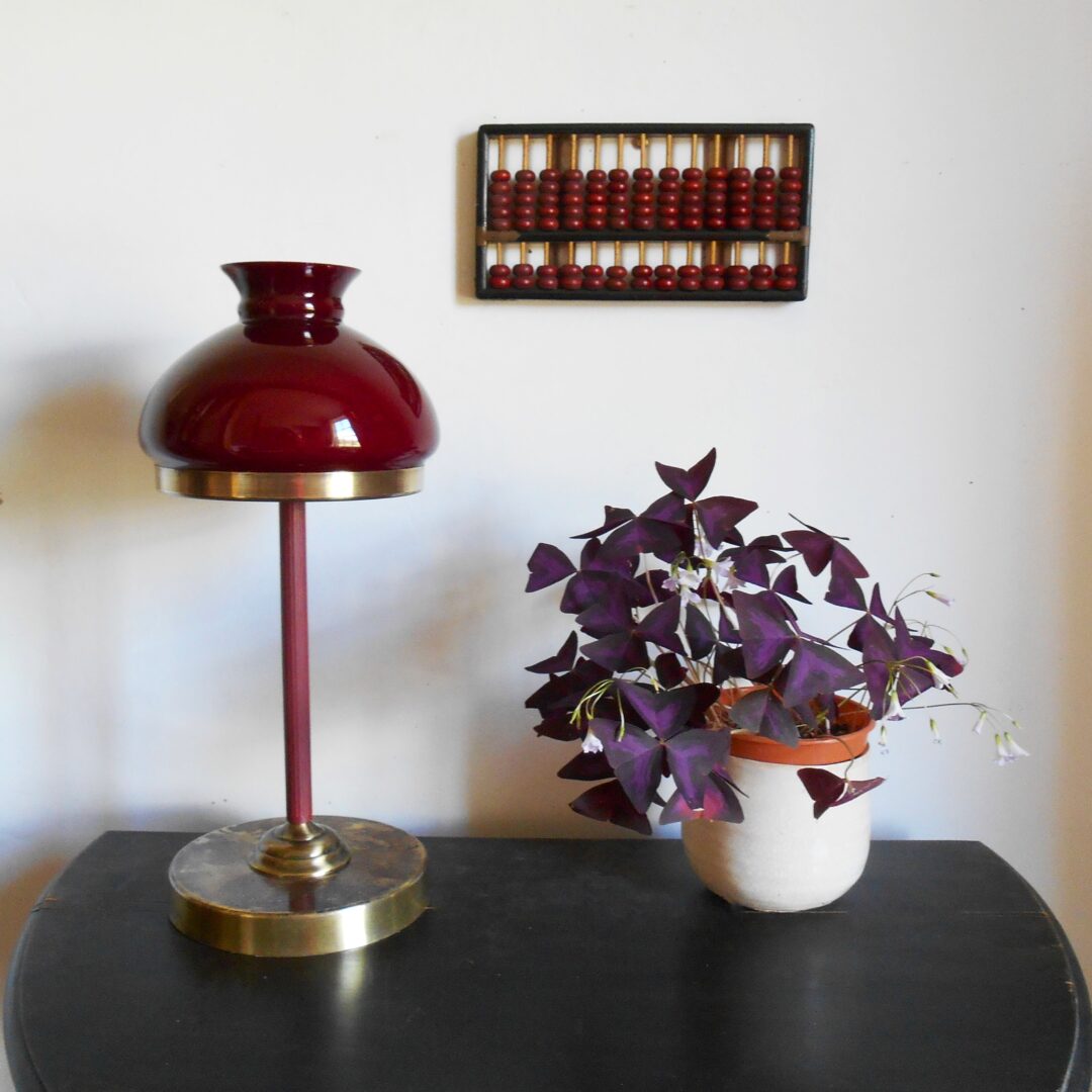 A burgundy glass cowl table lamp by Fiona Bradshaw Designs