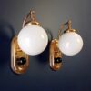 A pair of Art Deco style wall lamps with glass globe shades by Fiona Bradshaw Designs