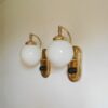A pair of Art Deco style wall lamps with glass globe shades by Fiona Bradshaw Designs