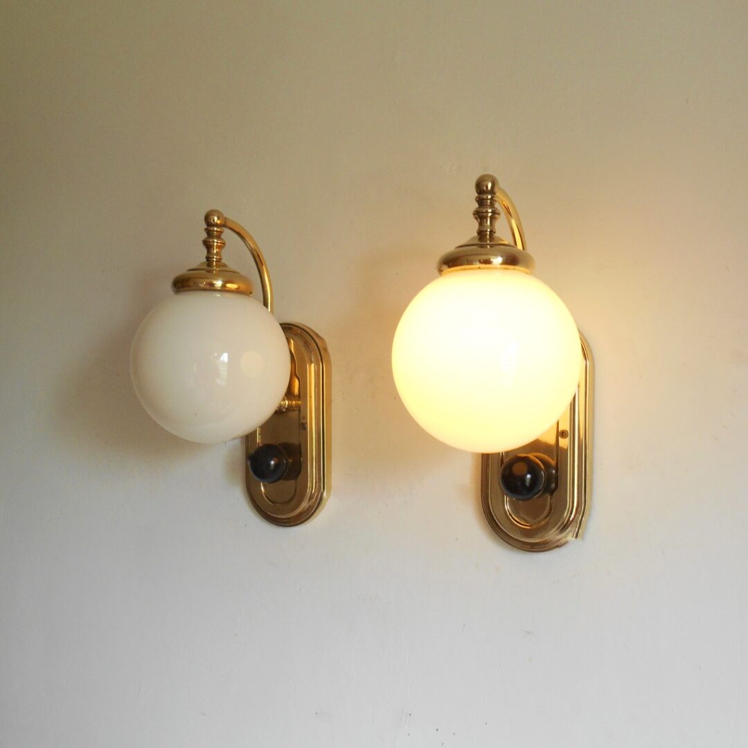 A pair of Art Deco style wall lamps with glass globe shades by Fiona Bradshaw Designs