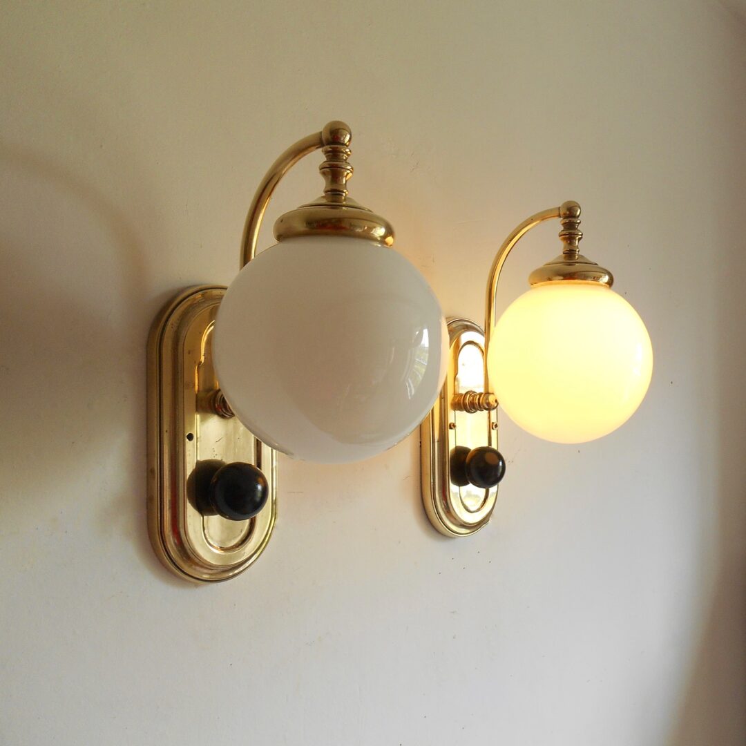 A pair of Art Deco style wall lamps with glass globe shades by Fiona Bradshaw Designs